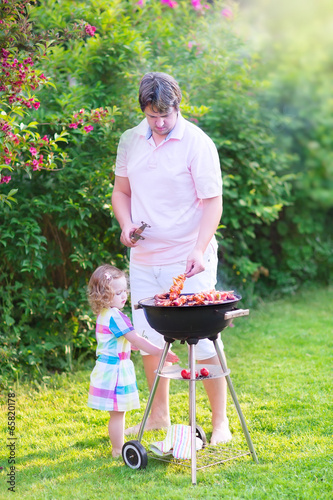 Father and daughter grilling in the garden