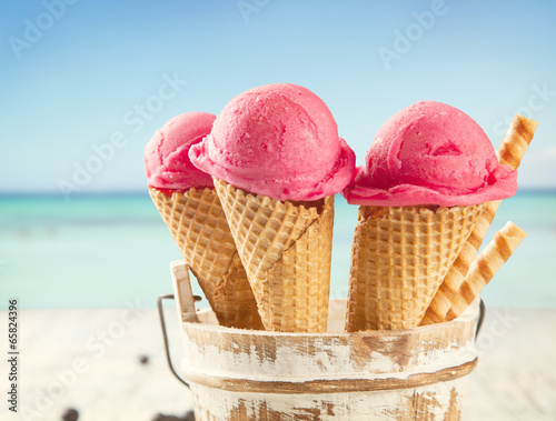 Canvas-taulu Ice cream scoops in cones with blur beach