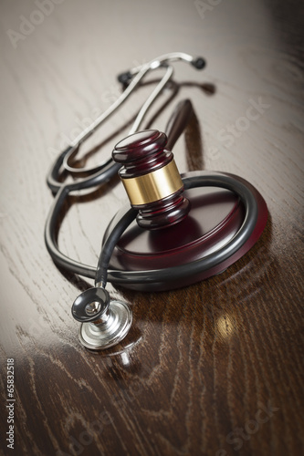 Gavel and Stethoscope on Reflective Table photo