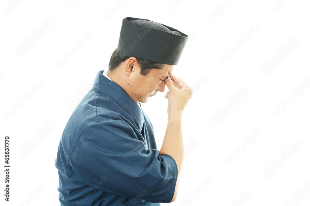 疲れた表情の寿司職人