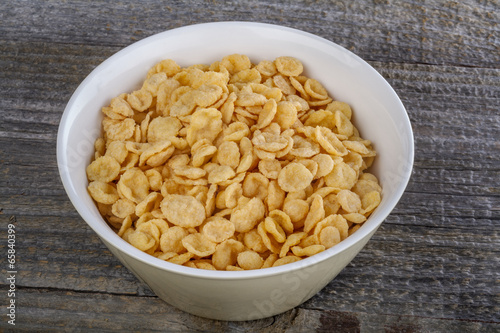 .closeup cornflakes in a bowl on a rustic table