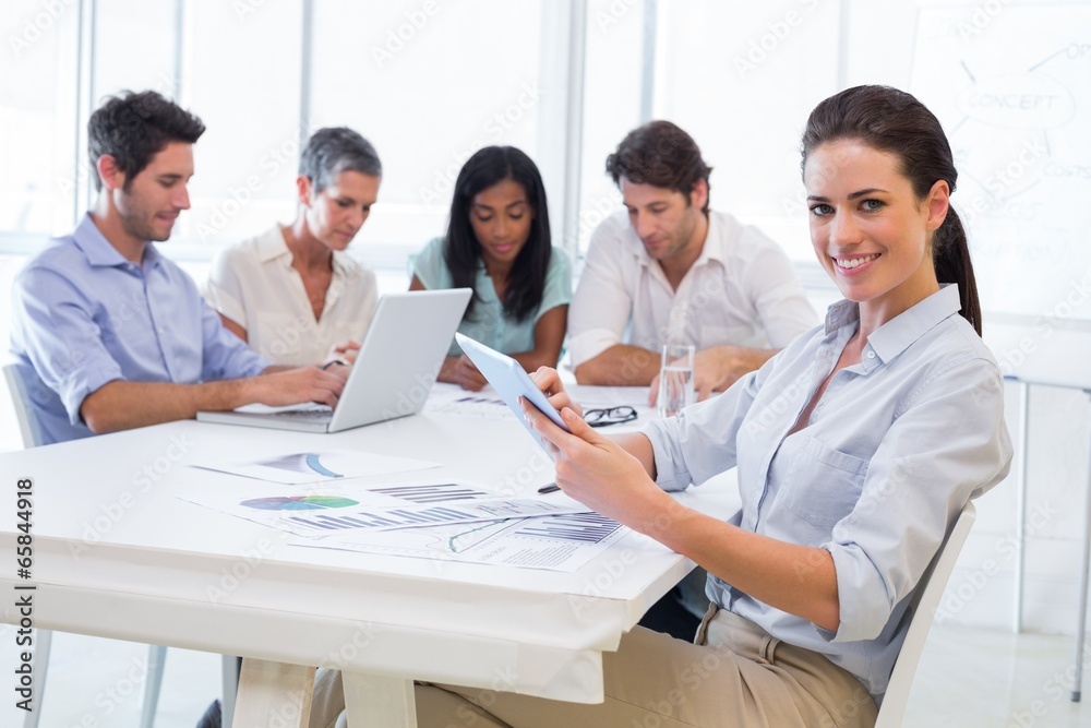 Pretty businesswoman using tablet device in business meeting Pretty businesswoman using tablet device in business meeting