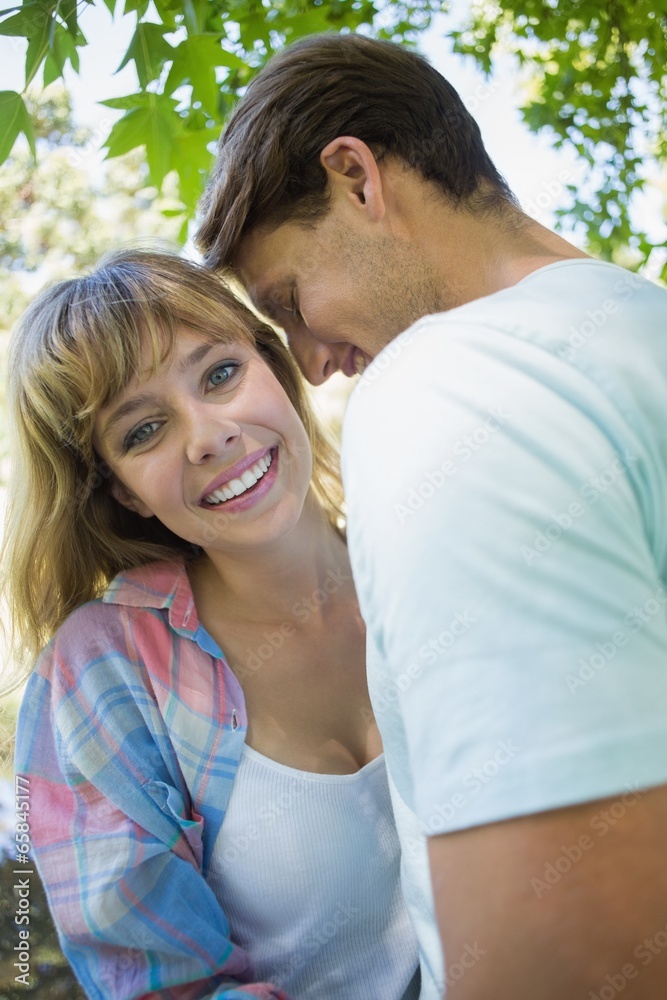 Pretty blonde smiling while hugging boyfriend in the park Pretty blonde smiling while hugging boyfriend in the park