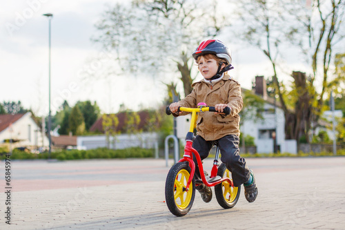Little toddler boy having fun and riding his bike