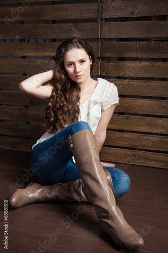 young woman in cowboy style clothes over wood