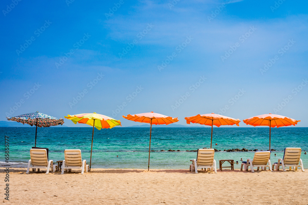 Beach umbrella and sunbath seats and side table