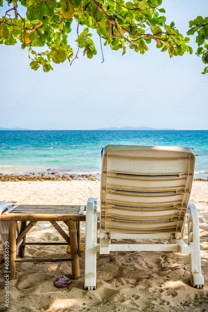 Beach chair and side table are on sand beach