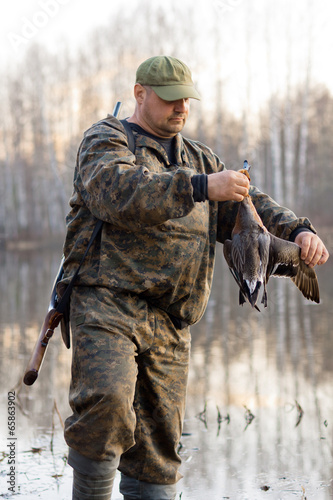 hunter holds a dead duck