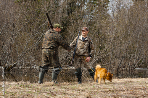 hunters shake hands on the shore