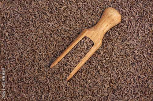Cumin seeds macro and wooden spoon as background