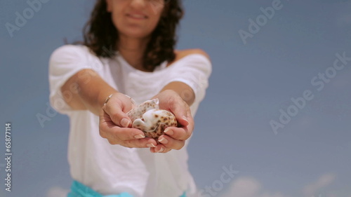 Woman showing shells on hands photo