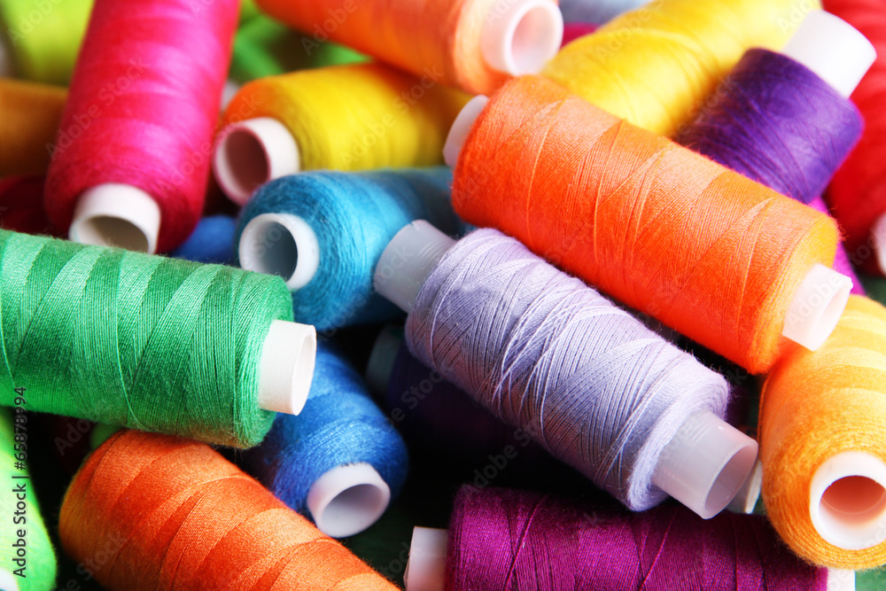Multicolor sewing threads on wooden background Multicolor sewing threads on wooden background