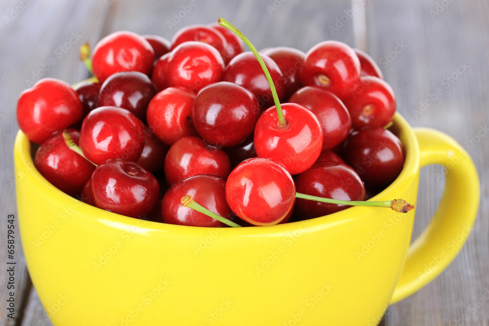 Sweet cherries in mug on wooden background Sweet cherries in mug on wooden background