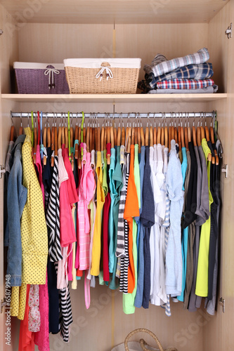 Colorful clothes hanging in wardrobe