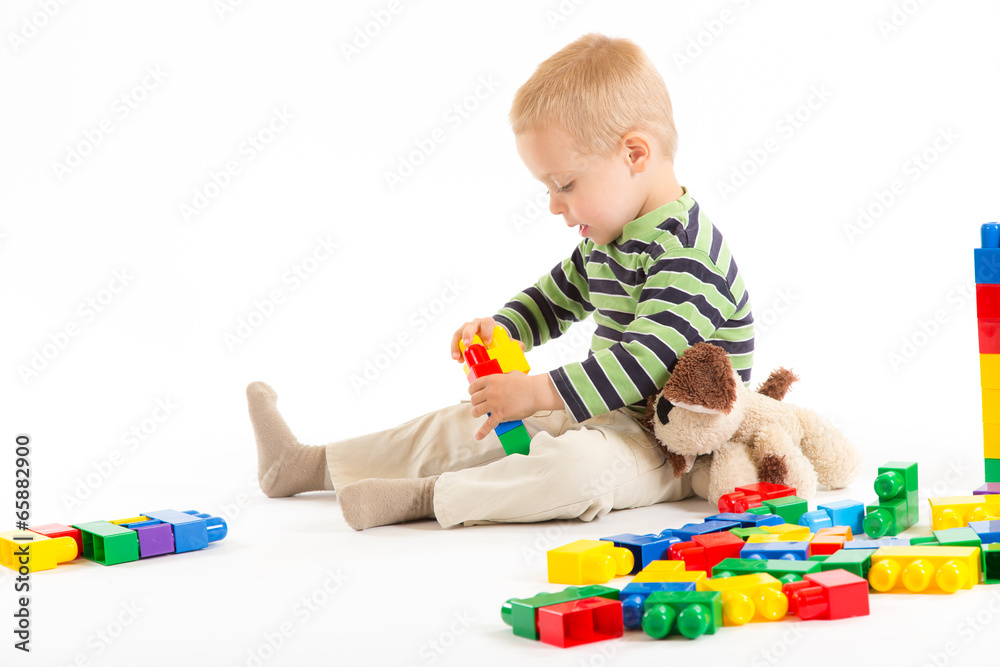 Little cute boy playing with building blocks. Isolated on white. Little cute boy playing with building blocks. Isolated on white.