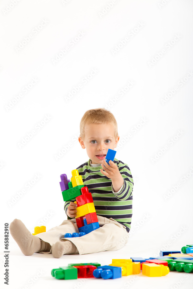 Little cute boy playing with building blocks. Isolated on white. Little cute boy playing with building blocks. Isolated on white.