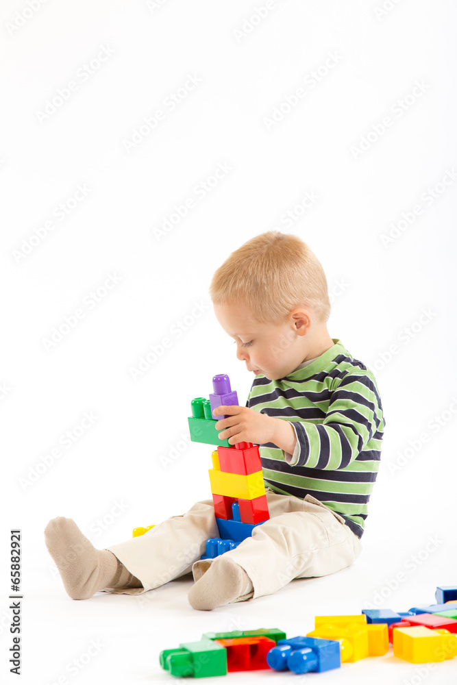 Little cute boy playing with building blocks. Isolated on white. Little cute boy playing with building blocks. Isolated on white.