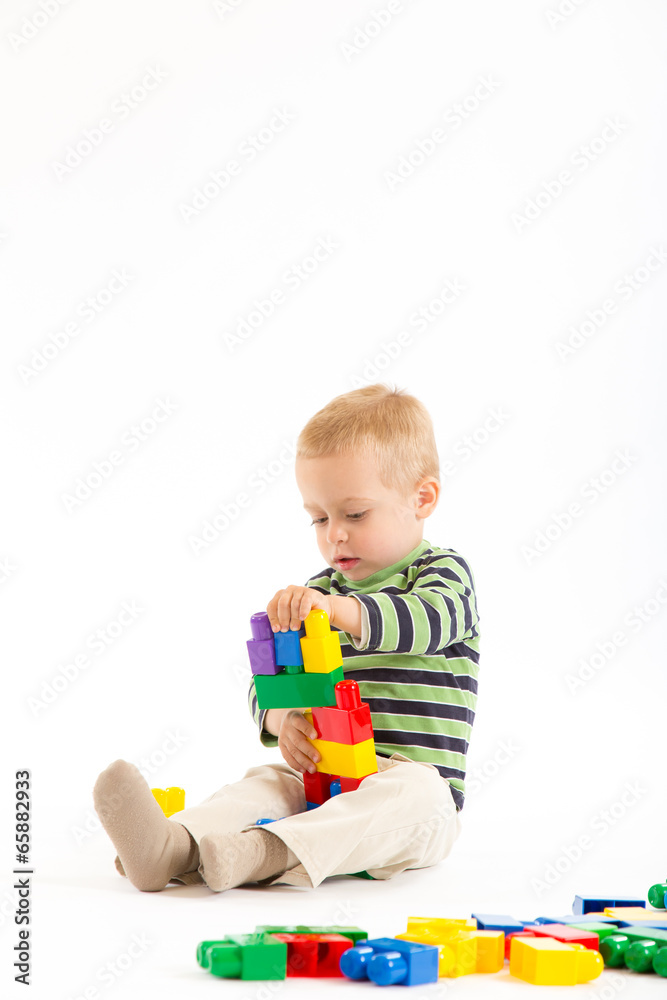 Little cute boy playing with building blocks. Isolated on white. Little cute boy playing with building blocks. Isolated on white.