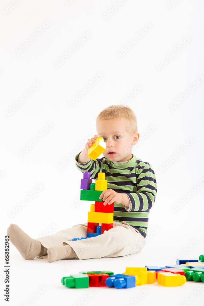 Little cute boy playing with building blocks. Isolated on white. Little cute boy playing with building blocks. Isolated on white.