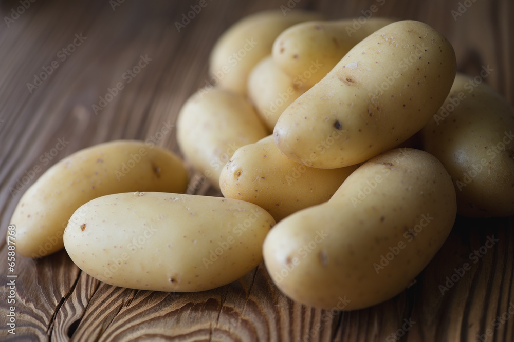 Raw potato over wooden background, close-up, horizontal shot Raw potato over wooden background, close-up, horizontal shot