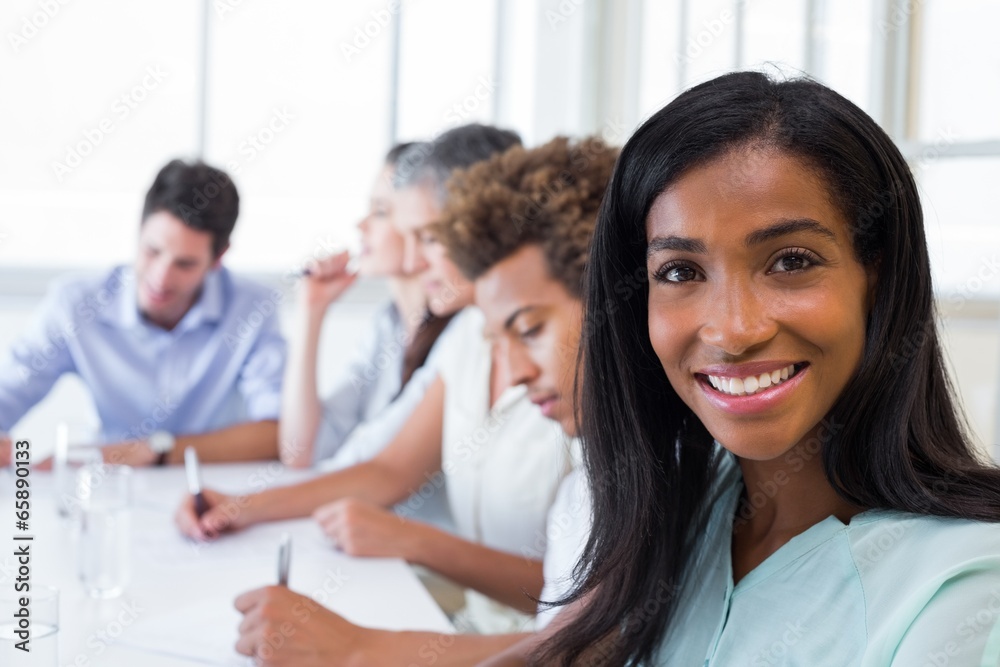 Casual businesswoman smiling at camera during meeting Casual businesswoman smiling at camera during meeting