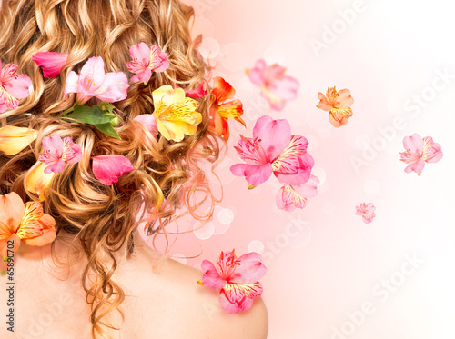 Beautiful healthy curly hair decorated with flowers