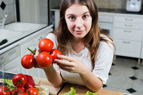 Young woman holding bunch of tomatoes