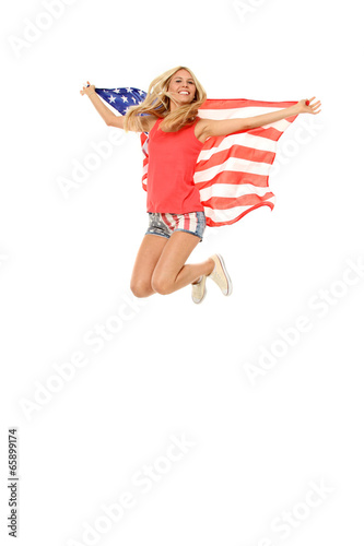 Hübsche Amerikanerin mit USA Flagge springt vor Freude