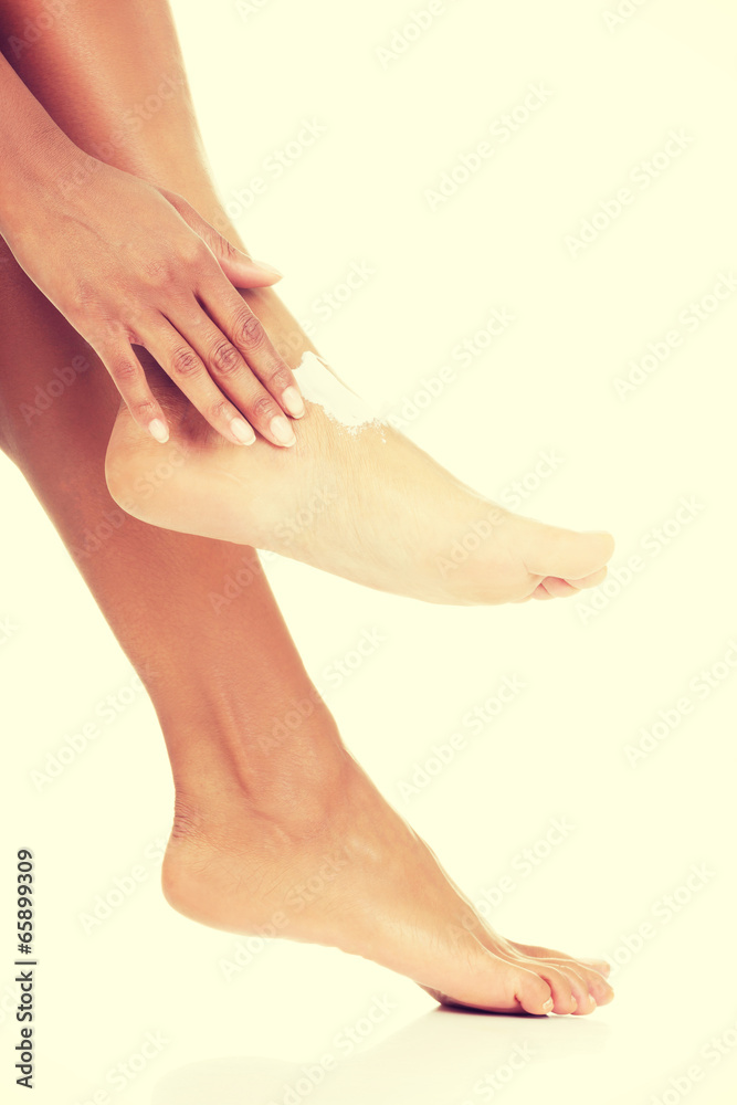 Female hands treating feet with moisturizing cream Female hands treating feet with moisturizing cream