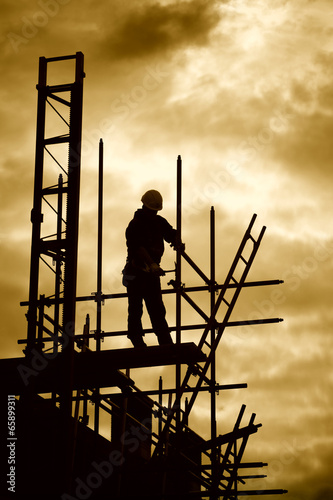 builder on scaffolding building site