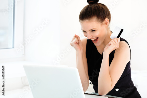 Happy Woman holding a credit card and shopping from the internet