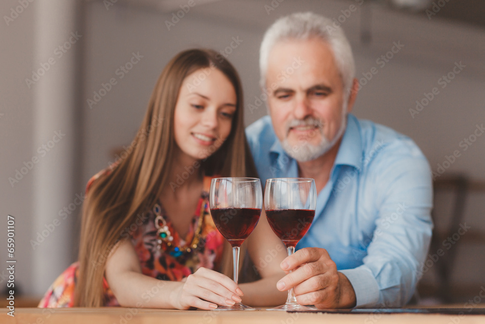 young girl and senior man holding wine glasess young girl and senior man holding wine glasess