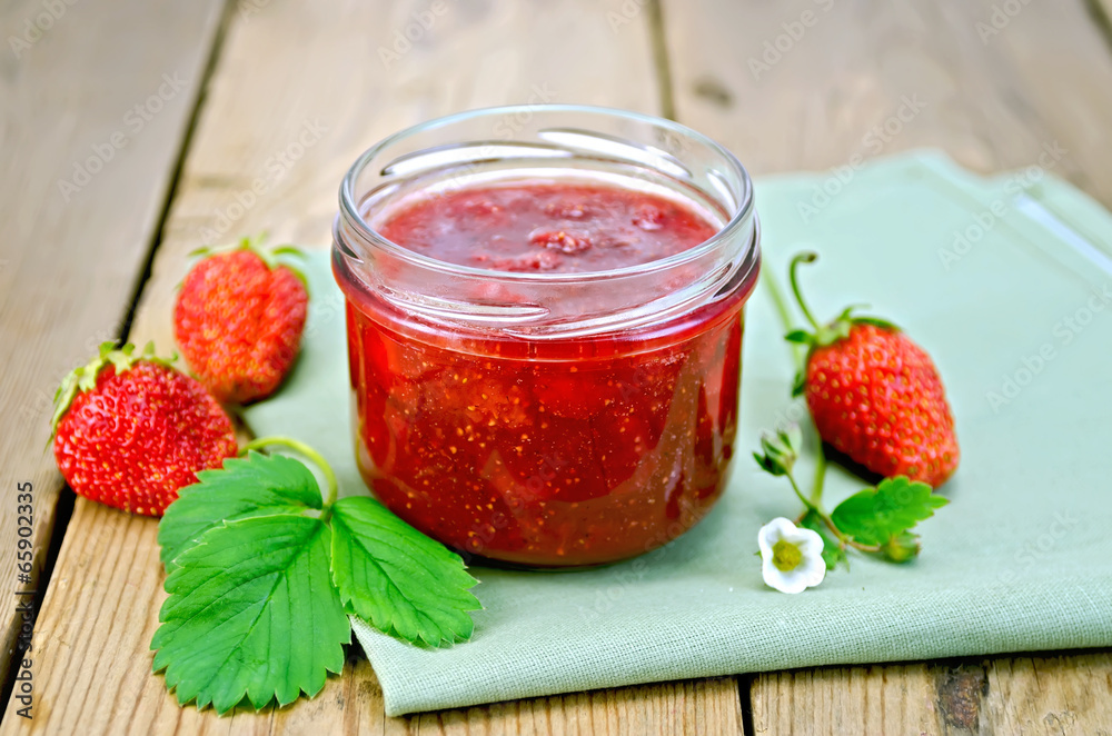 Jam of strawberry with berries and leaf on board Jam of strawberry with berries and leaf on board