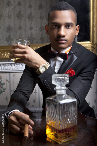 Elegante handsome black gentleman drinks scotch whiskey