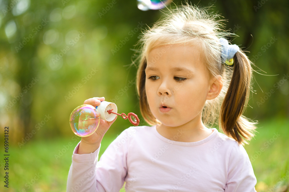 Little girl is blowing a soap bubbles Little girl is blowing a soap bubbles
