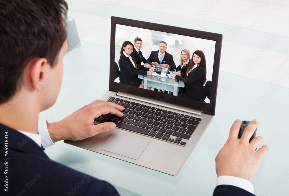Businessman Video Conferencing On Laptop In Office - obrazy, fototapety, plakaty 