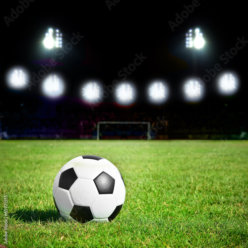 football on the grass field with stadium light