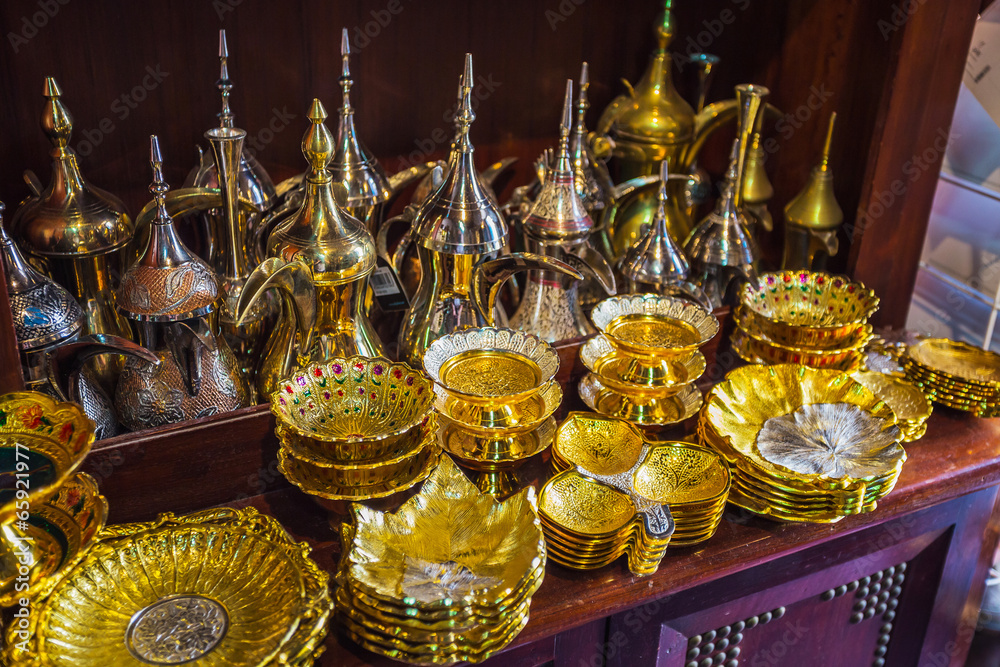 row of shiny traditional coffee pots and lamp