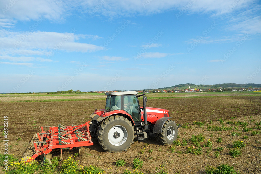 Traktor mit Egge und Cambridge Walzen am Feld Traktor mit Egge und Cambridge Walzen am Feld