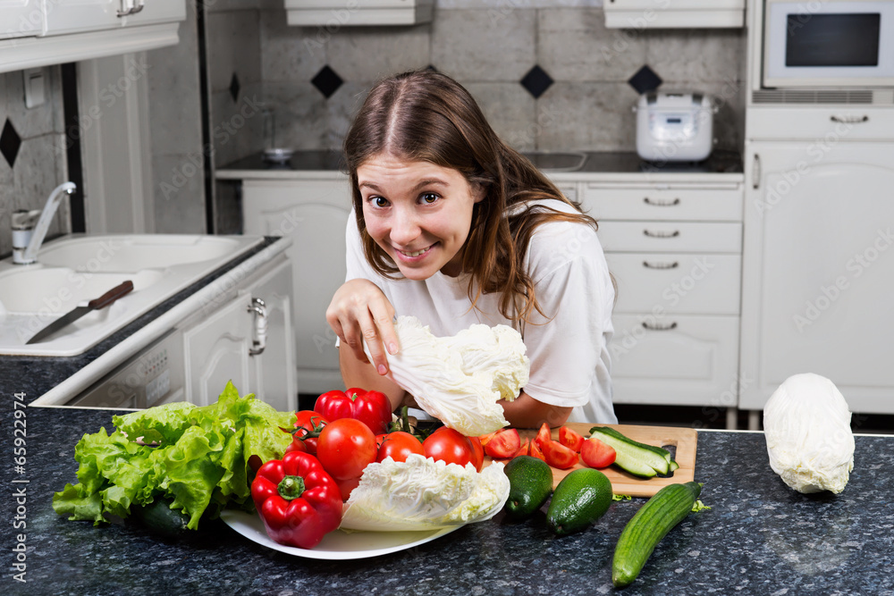 Young female cook making a fresh salad with organic vegetables Young female cook making a fresh salad with organic vegetables