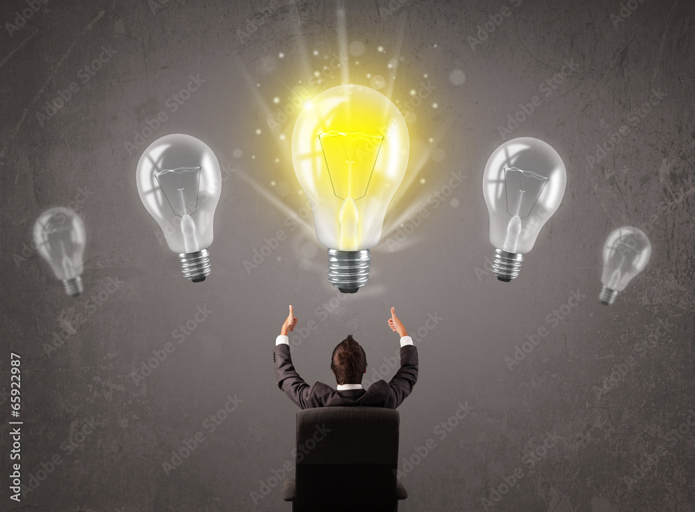 Business person having an idea light bulb concept - obrazy, fototapety, plakaty 