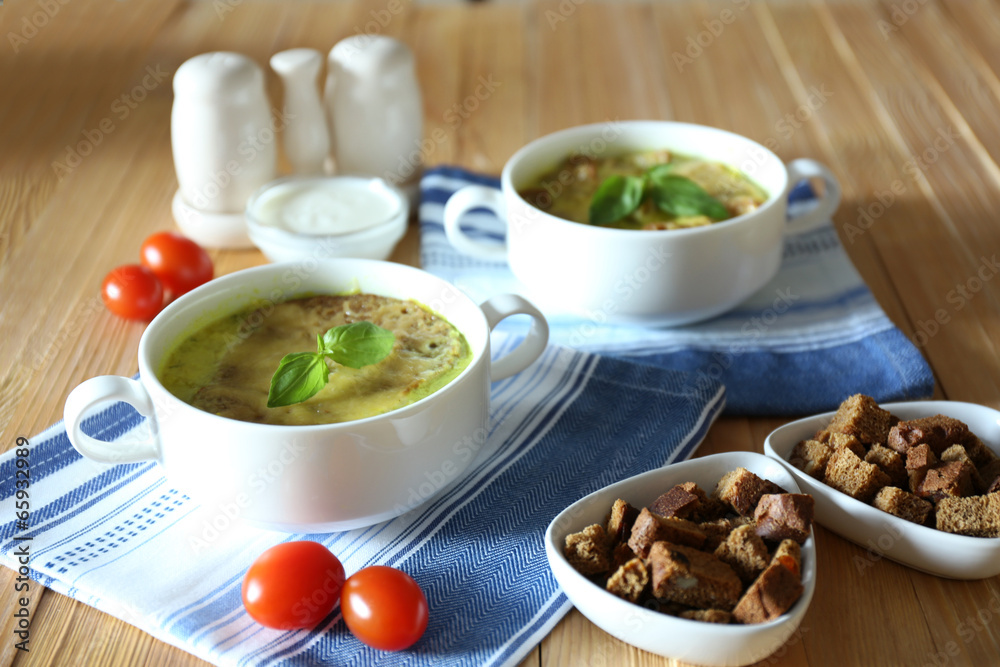 Tasty soup in saucepans on wooden table, close up Tasty soup in saucepans on wooden table, close up