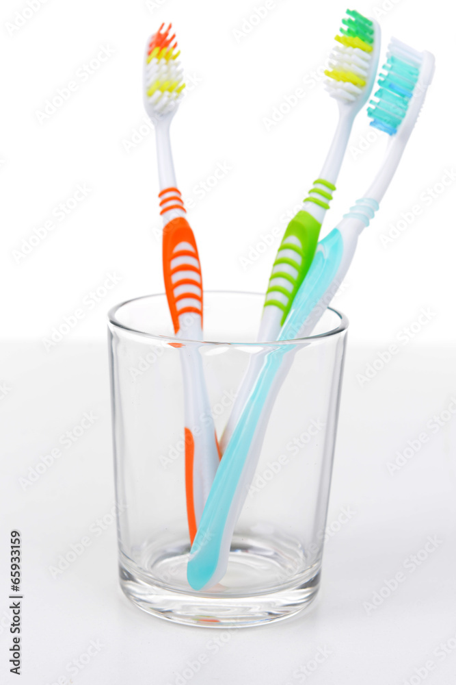 Toothbrushes in glass isolated on white Toothbrushes in glass isolated on white