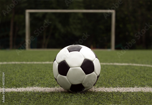 White and black ball for playing soccer against gate close-up photo