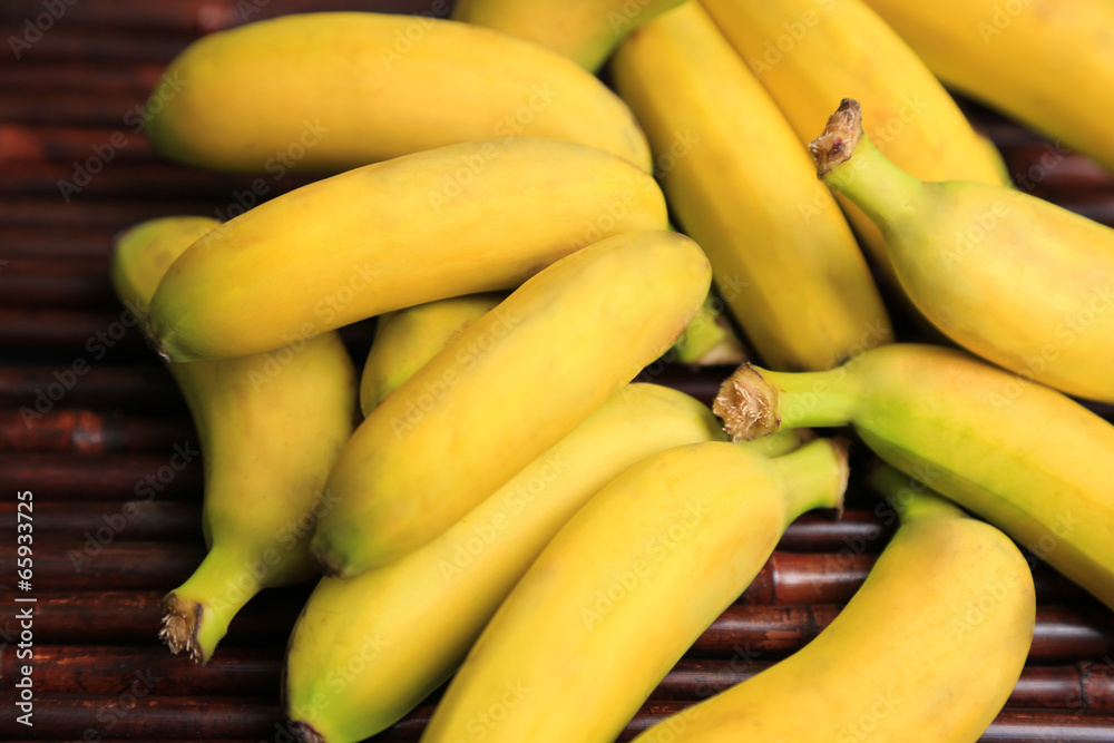 Bunch of mini bananas on bamboo mat background Bunch of mini bananas on bamboo mat background