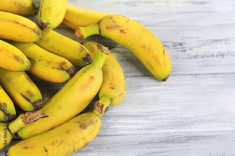 Bunch of mini bananas on color wooden background
