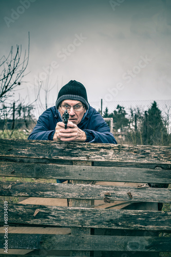 Senior man aiming a gun