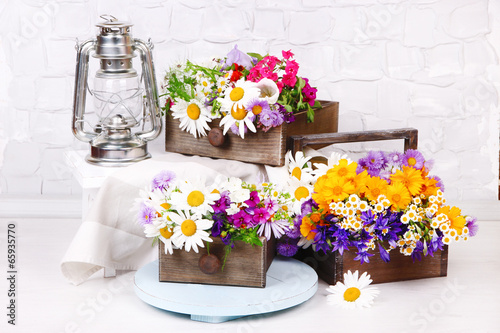 Fototapeta Naklejka Na Ścianę i Meble -  Beautiful flowers in crates with kerosene lamp
