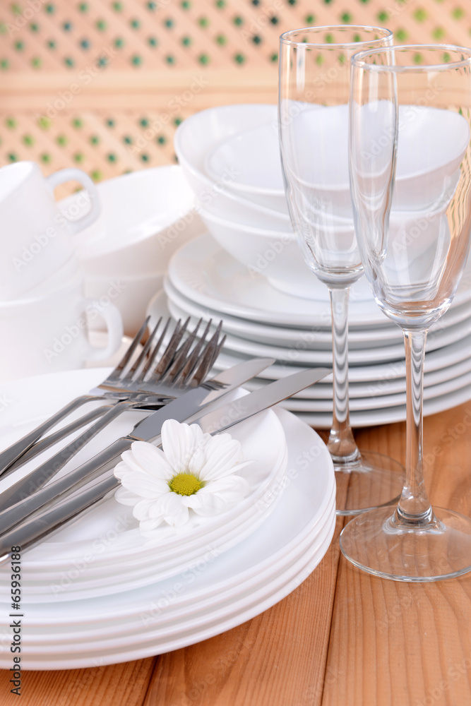 Set of white dishes on table on light background Set of white dishes on table on light background
