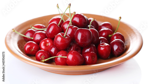 Sweet cherry on color plate isolated on white